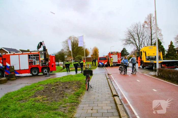 Brandweer takelt auto uit greppel
