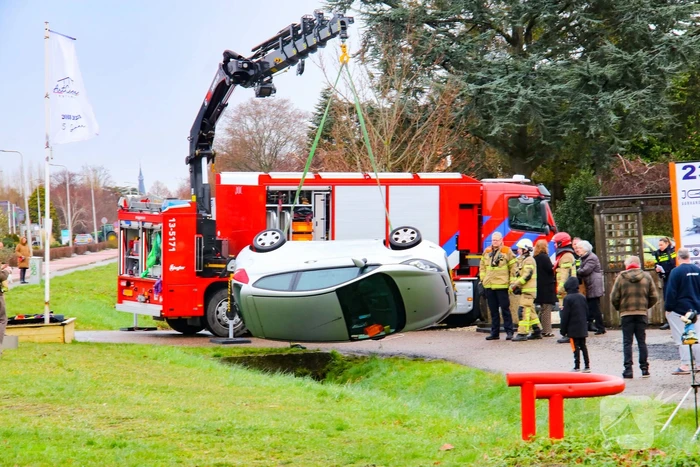 Brandweer takelt auto uit greppel
