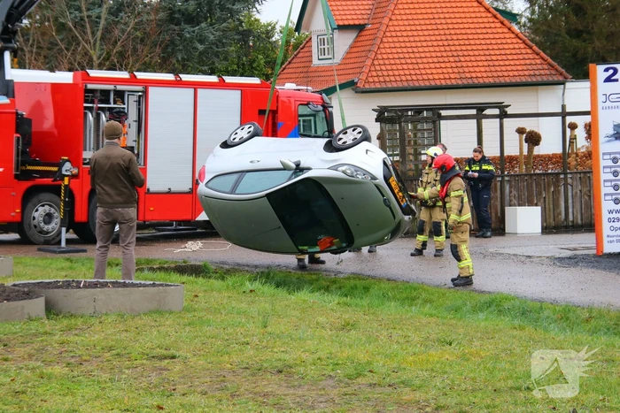 Brandweer takelt auto uit greppel