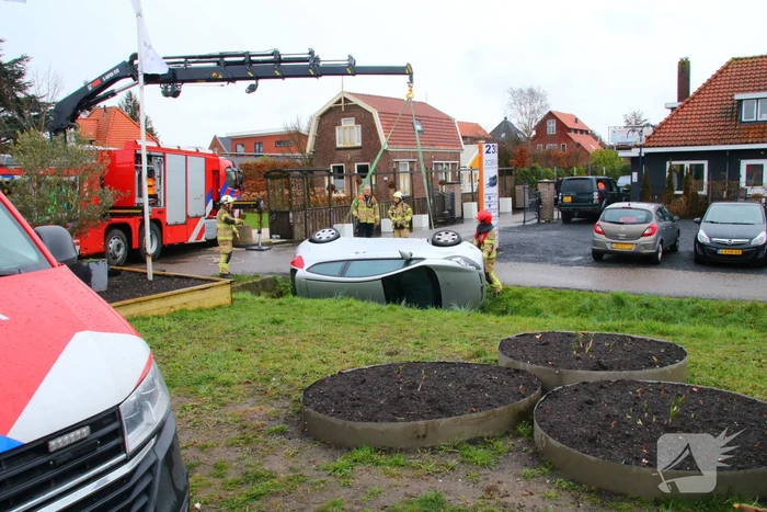Brandweer takelt auto uit greppel