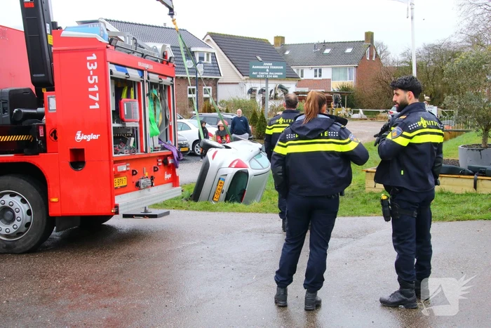 Brandweer takelt auto uit greppel
