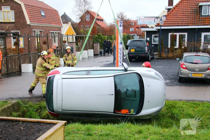 Brandweer takelt auto uit greppel