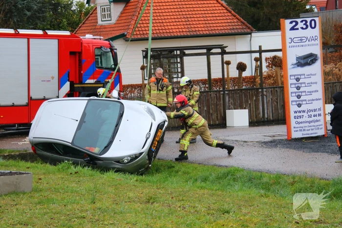 Brandweer takelt auto uit greppel