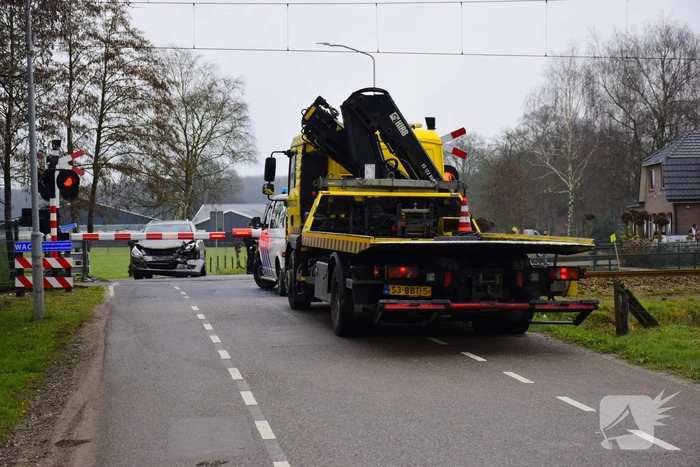 Twee auto's botsen tegen elkaar bij spoorwegovergang