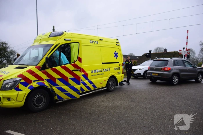 Twee auto's botsen tegen elkaar bij spoorwegovergang