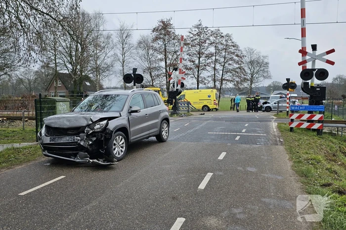 Twee auto's botsen tegen elkaar bij spoorwegovergang