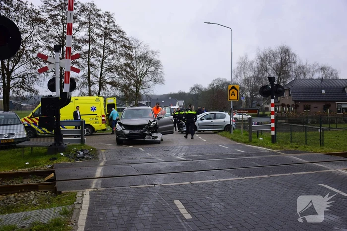 Twee auto's botsen tegen elkaar bij spoorwegovergang