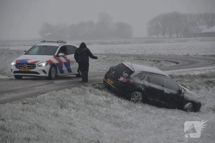 Twee personenauto's in berm van dijk belandt