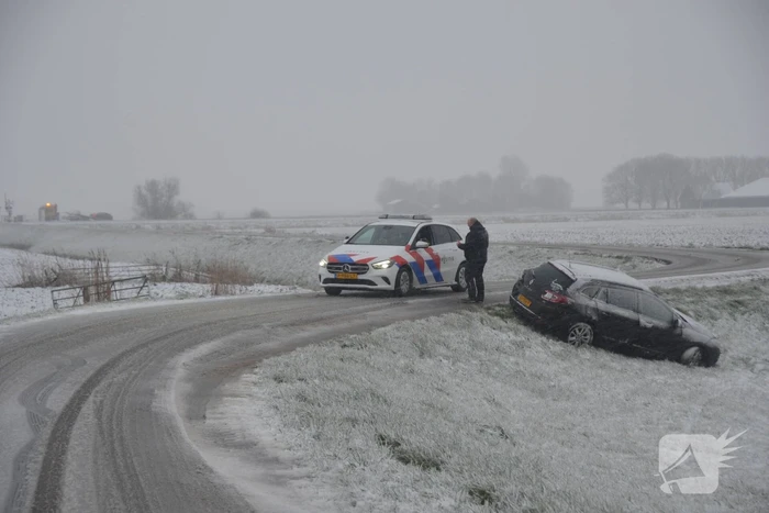 Twee personenauto's in berm van dijk belandt