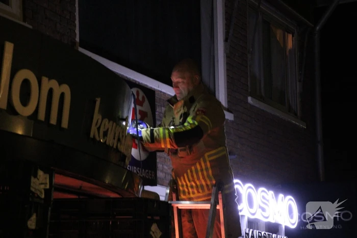 Reclamebord dreigt naar beneden te vallen
