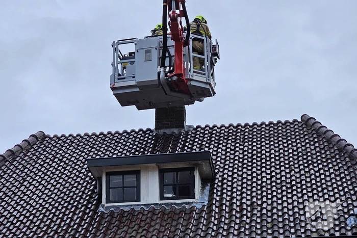 Brandweer veegt schoorsteen na brand