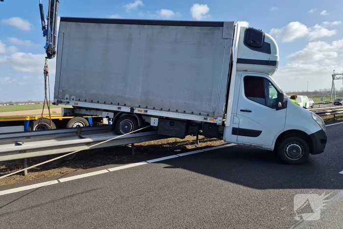 Bakwagen waait op vangrail