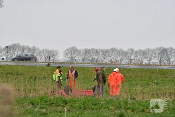 Auto belandt op zijn kop naast snelweg