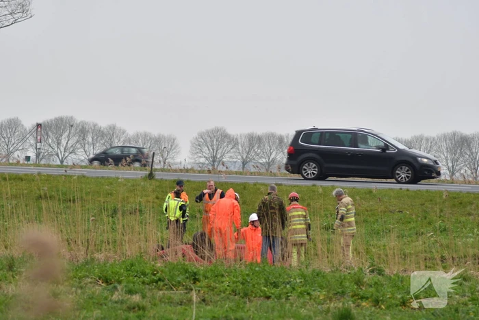 Auto belandt op zijn kop naast snelweg