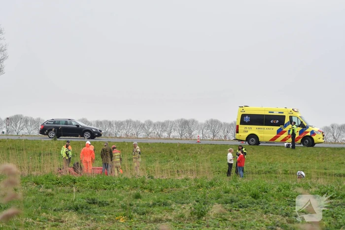 Auto belandt op zijn kop naast snelweg