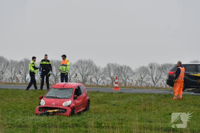 Auto belandt op zijn kop naast snelweg