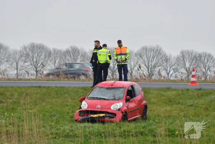 Auto belandt op zijn kop naast snelweg