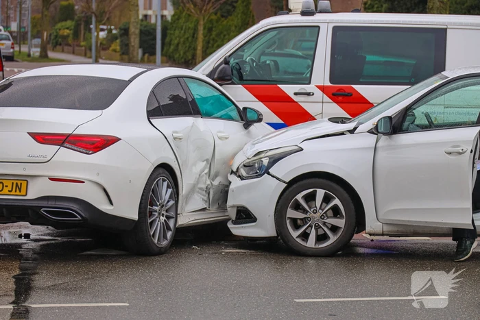 Twee personenauto's botsen op elkaar op kruising