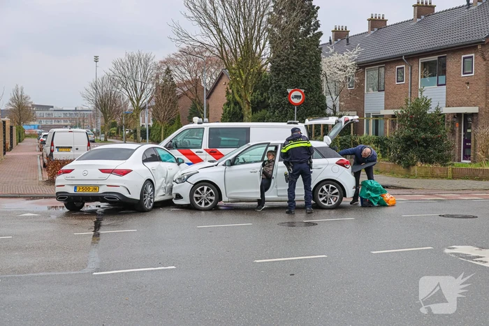 Twee personenauto's botsen op elkaar op kruising