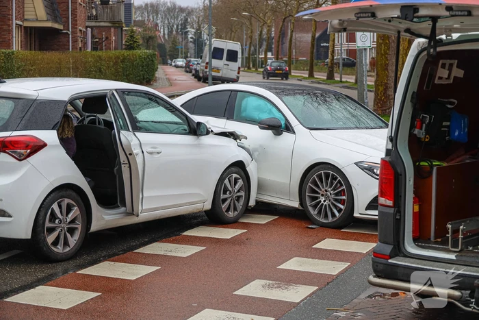 Twee personenauto's botsen op elkaar op kruising