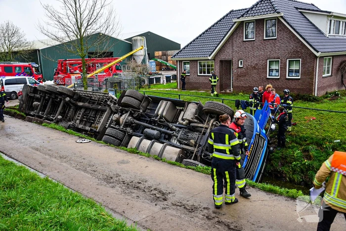 Chauffeur bekneld nadat vrachtwagen in sloot belandt