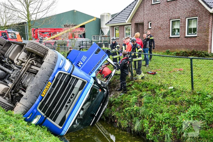 Chauffeur bekneld nadat vrachtwagen in sloot belandt