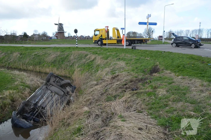 Bestelbus belandt in de sloot na botsing met auto