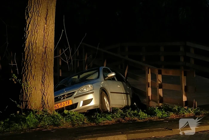 Auto vast tussen boom en brug, inzittenden slaan op de vlucht