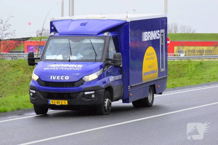 Politie bewaakt geldwagen met lekke band
