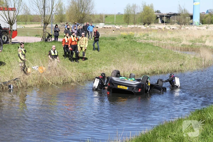 Auto ondersteboven te water geraakt