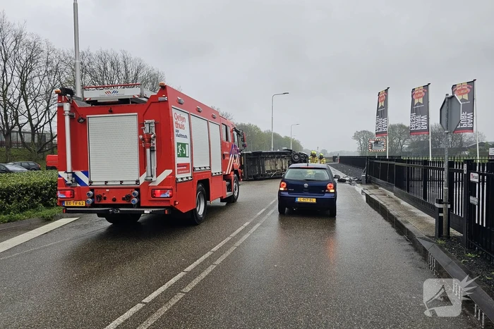 Bestelbus botst op hek en belandt op zijkant