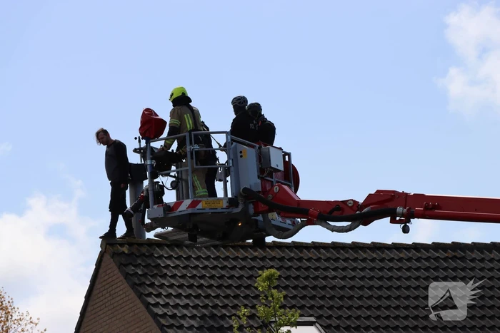 Twee personen op dak van woning