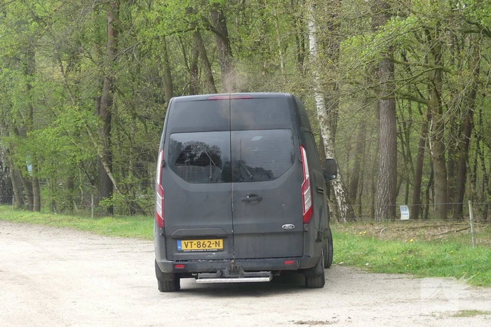 Bestelbus met afval in brand gestoken op parkeerplaats bij bos, twee aanhoudingen
