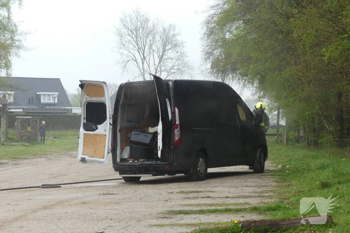 Bestelbus met afval in brand gestoken op parkeerplaats bij bos, twee aanhoudingen