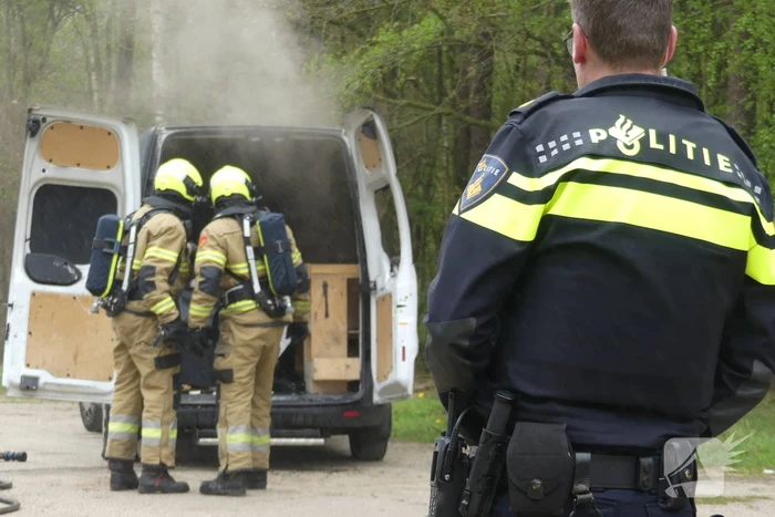 Bestelbus met afval in brand gestoken op parkeerplaats bij bos, twee aanhoudingen