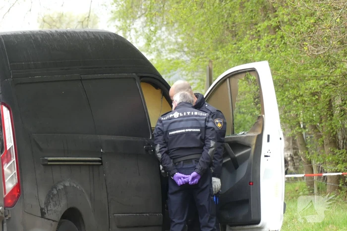 Bestelbus met afval in brand gestoken op parkeerplaats bij bos, twee aanhoudingen