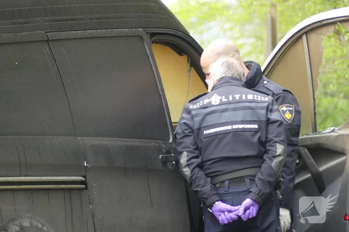 Bestelbus met afval in brand gestoken op parkeerplaats bij bos, twee aanhoudingen