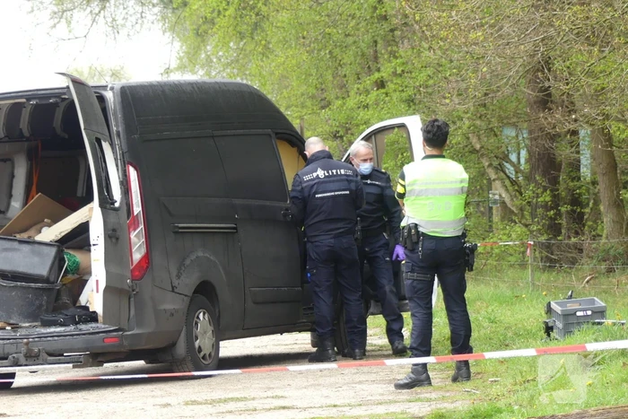 Bestelbus met afval in brand gestoken op parkeerplaats bij bos, twee aanhoudingen