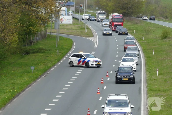Auto en aanhanger met graafmachine over de kop