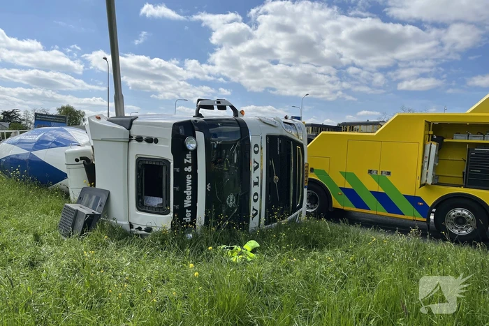 Vrachtwagen met betonmixer oplegger gekanteld