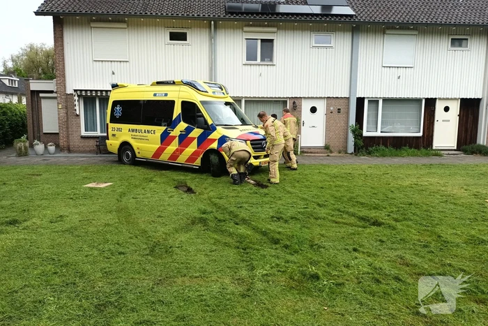 Ambulance rijdt zich vast op grasveld voor woning
