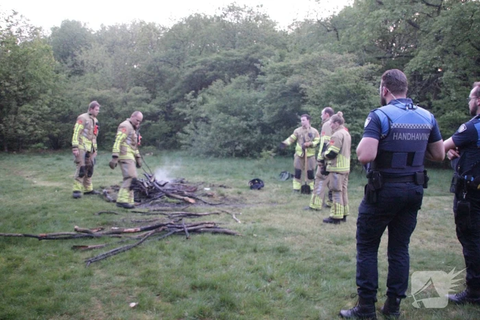 Brandweer blust kampvuur in bos