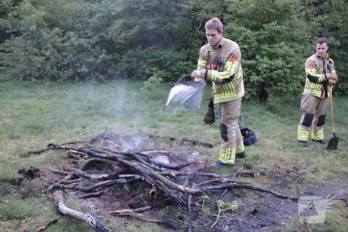 Brandweer blust kampvuur in bos