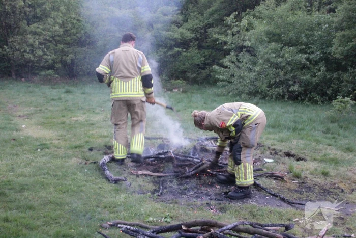 Brandweer blust kampvuur in bos