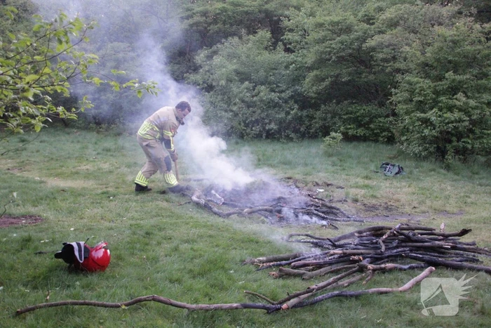 Brandweer blust kampvuur in bos