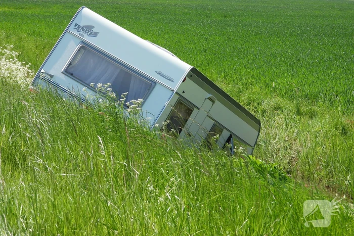 Caravan raakt los van auto en belandt in sloot
