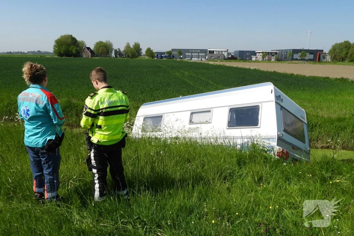 Caravan raakt los van auto en belandt in sloot