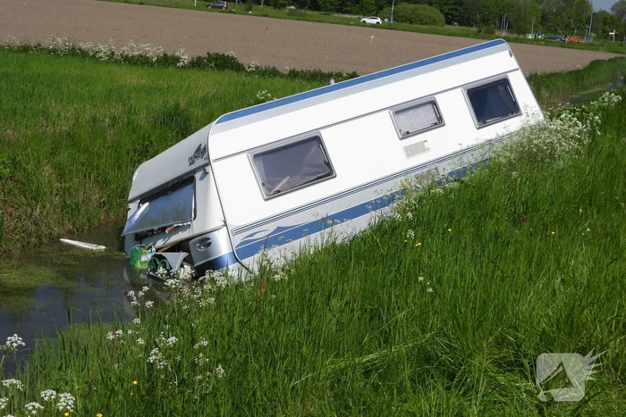 Caravan raakt los van auto en belandt in sloot