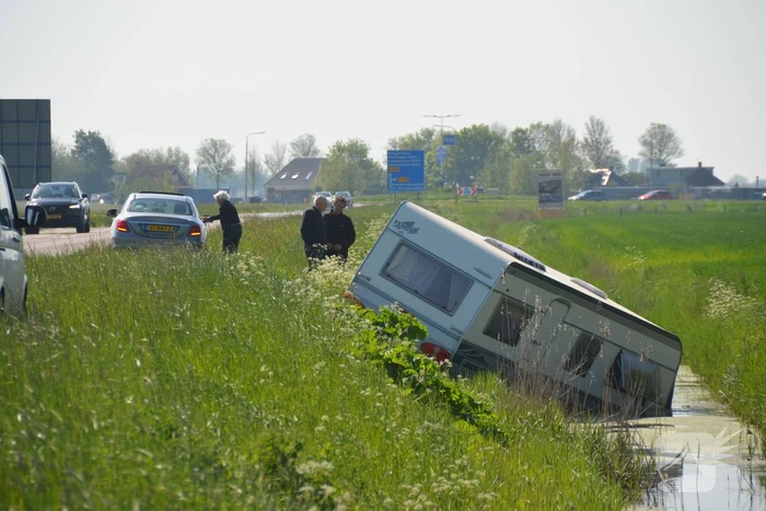 Caravan raakt los van auto en belandt in sloot