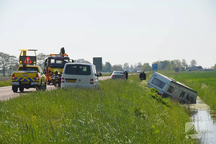 Caravan raakt los van auto en belandt in sloot
